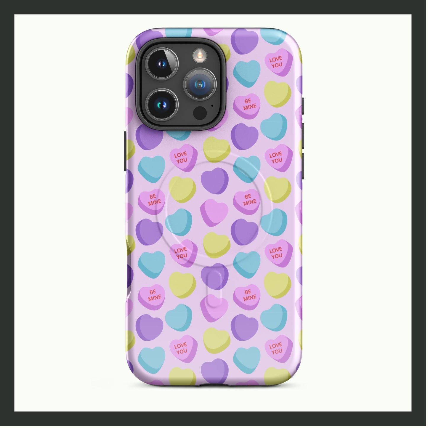 A MagSafe® tough case for iPhone® featuring a pastel candy heart pattern with messages like "Love You" and "Be Mine" on a light pink background. The case combines stylish charm with dual-layer protection and MagSafe® compatibility. Perfect for a playful and functional phone accessory!