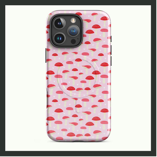 A MagSafe® tough iPhone® case with a playful red and white mushroom pattern on a pastel pink background. This dual-layer case provides premium protection with a quirky and whimsical design, perfect for nature lovers!