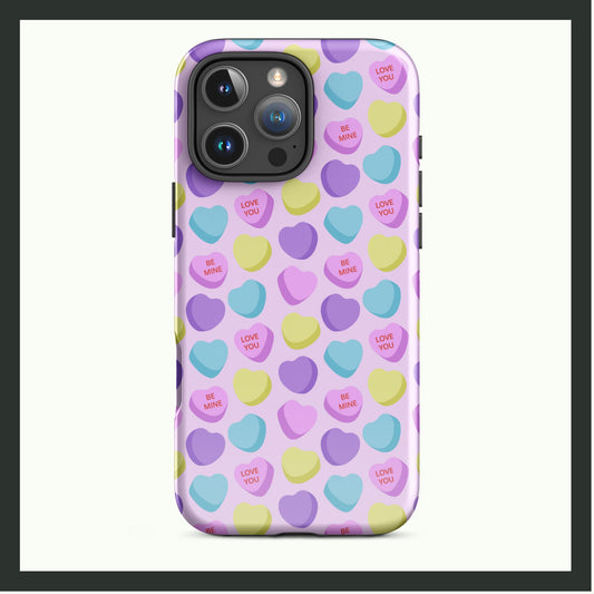 A tough iPhone® case featuring a pastel candy heart pattern with loving messages on a light pink background. This dual-layer case provides durable protection with a fun and playful design. Perfect for Valentine's Day or everyday use!