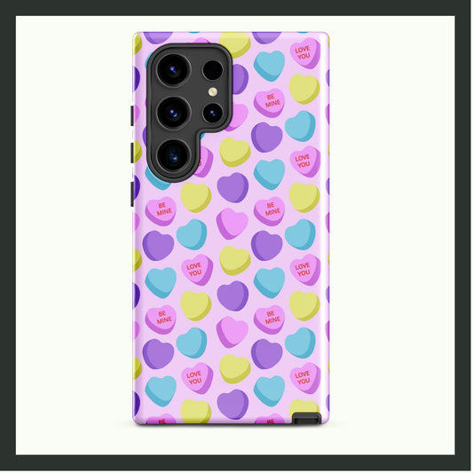 A tough Samsung® phone case with a pastel candy heart pattern, featuring messages like "Love You" and "Be Mine" on a light pink background. This dual-layer case provides stylish charm and reliable protection. Perfect for Valentine’s Day or everyday use!